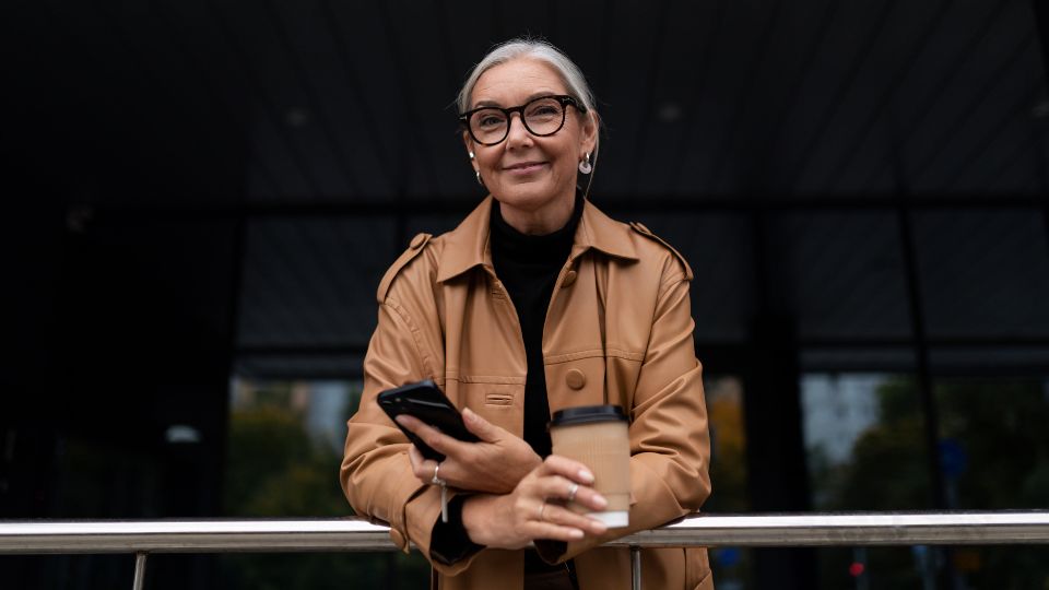 Mujer sonriendo y planificando cómo invertir después de los 50 años